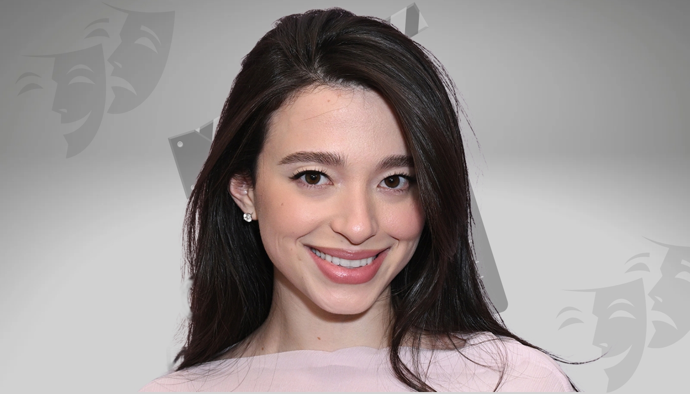 Close-up of Mikey Madison smiling, wearing a light pink outfit with diamond earrings