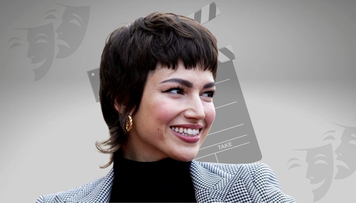 Úrsula Corberó smiling in a stylish outfit with short hair and gold earrings