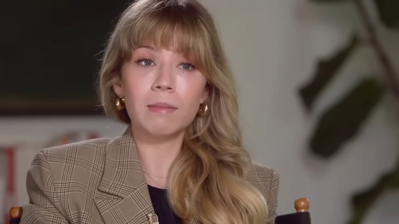 Jennette McCurdy sits in a chair wearing a plaid blazer, looking calm and thoughtful