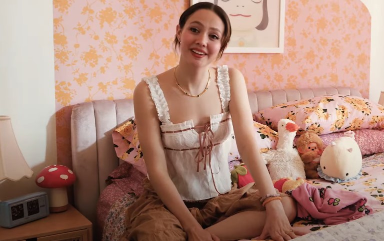 Iris Apatow smiling while sitting on a couch