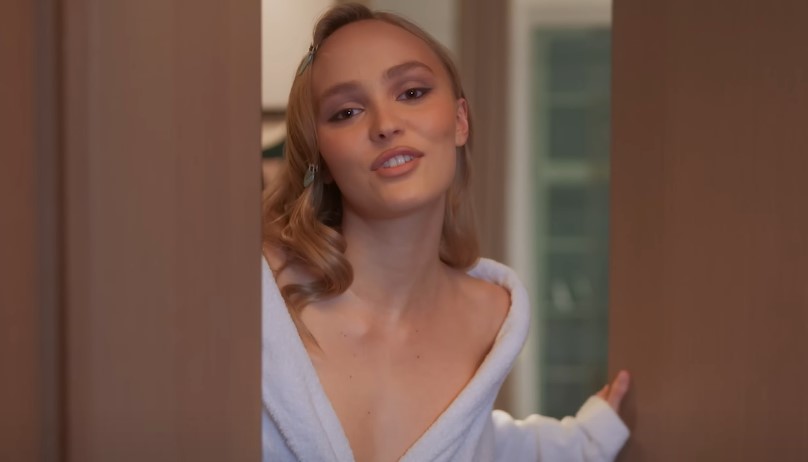 Lily-Rose Depp peeks out from behind a doorframe