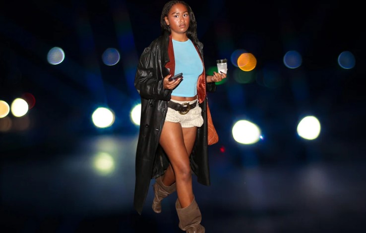 Sasha Obama is pictured on a night-time street with blurred lights in the background